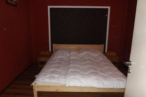a bedroom with a bed with a white comforter at Napsugár Vendégház in Keszthely +3 photos