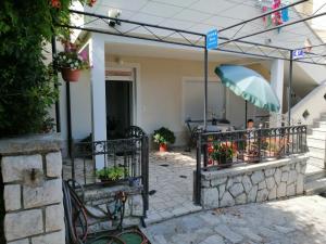a patio with a fence with flowers and an umbrella at Lina at the best in Krk