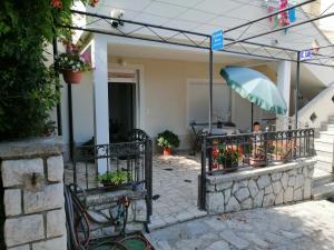 patio z ogrodzeniem z kwiatami i parasolem w obiekcie Lina at the best w Krku