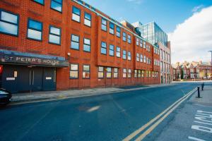 an empty street in front of a red brick building at Cosy Executive City Apartment in Doncaster