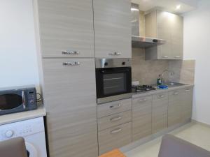 a kitchen with stainless steel cabinets and a microwave at Aquamarine Sea Front Apartments - Second Floor in Marsaskala