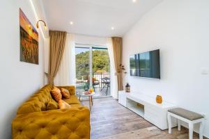 a living room with a couch and a tv at Corallium Lux in Pomena