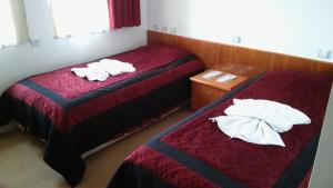 two beds in a hotel room with towels on them at Hotel Baykal in Bogazkale