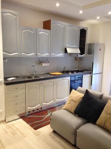 uma cozinha com armários brancos e um sofá num quarto em Casarimidia em Perugia