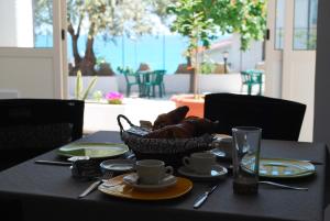 een tafel met een mand met croissants en bekers erop bij Evergreen in Roseto Capo Spulico