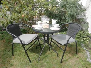 a black table with two chairs and a tea set at Pokoje przy fontannie in Karwia
