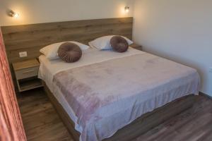 a bedroom with a large bed with two pillows on it at Apartman Joso 3 in Sukošan