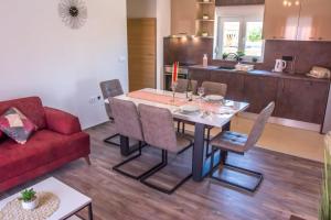 a living room with a table and a red couch at Apartman Joso 3 in Sukošan