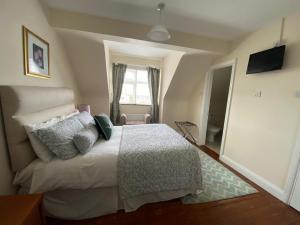 a bedroom with a white bed and white walls at Fernhill House Tramore B&B in Tramore