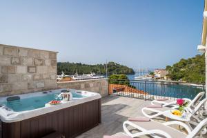 a hot tub on a patio with a view of the water at Corallium Lux in Pomena