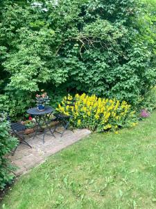 einen Tisch und Stühle in einem Garten mit Blumen in der Unterkunft Yxnaholma Rum in Höör