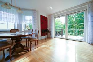 a dining room with a table and chairs and large windows at Haus Johanna in Malchow