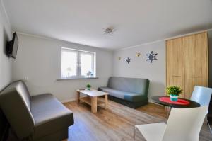 a living room with two chairs and a table at Fala Dziwnow in Dziwnów