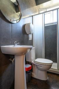 a bathroom with a sink and a toilet and a mirror at Terrace Lisbon Hostel in Lisbon +53 photos