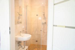 a bathroom with a sink and a shower at Promyki - Domki Apartamentowe in Chłopy