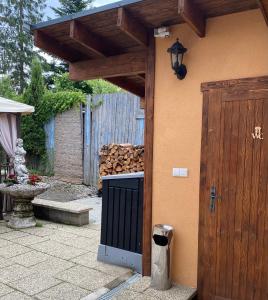 a building with a gate and a pile of fire wood at Penzión Vila Petra Bed&Breakfast in Veľký Slavkov