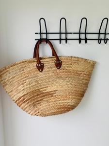 a rattan basket hanging on a wall at Studio49 in Ouddorp