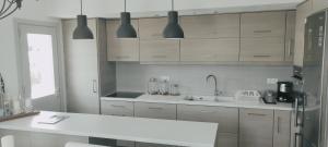 a kitchen with white cabinets and a white counter top at Akrotiri Villas Skyros in Skiros +147 photos