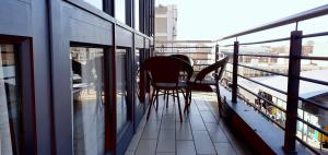 a balcony with chairs and tables on a building at Alcazaba Hotel in Johannesburg