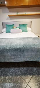 - duże łóżko z niebieskimi poduszkami w pokoju w obiekcie Apartamento Camariñas w mieście Camariñas