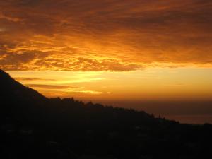 a sunset over a hill with the sun setting in the background at Honny - Boutique Hotel in Amirim