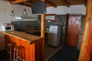 Lodge en Farellones في سانتياغو: مطبخ مع ثلاجة وكاونتر مع الكراسي