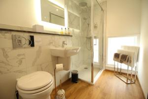 a white bathroom with a toilet and a sink at Number 8 in Canterbury
