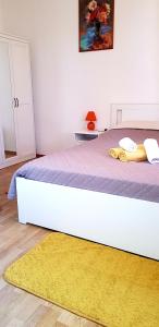 a bedroom with a large white bed with a yellow rug at Room Cvita in Trogir