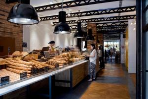 un par de personas de pie en un mostrador en una panadería en Praktik Bakery en Barcelona