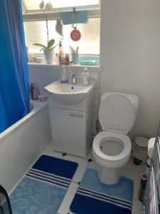 a bathroom with a toilet and a sink and a tub at Single Unique Room For Professionals in Ealing