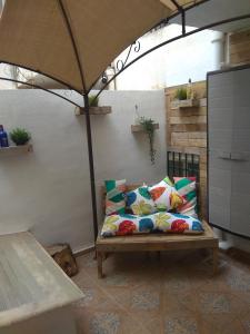 un sofá sentado bajo una sombrilla en un patio en Apartment Avenida Pinoso, en El Pinós (Pinoso)