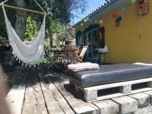 a porch with a hammock and a table and chairs at Casa S. Nicolau in Cabeceiras de Basto