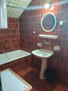 y baño con lavabo, espejo y bañera. en HOSTEL BATA II Trokrevetne sobe, en Kanjiža