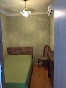 a small bedroom with a green bed and a desk at Apartment for you in Tbilisi City