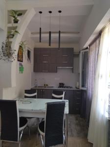 a kitchen and dining room with a white table and chairs at Apartment for you in Tbilisi City