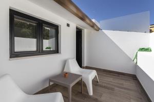 Zimmer mit 2 weißen Stühlen und einem Tisch in der Unterkunft Casa da Praca - City Center - Faro in Faro