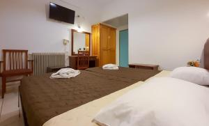 pokój hotelowy z dwoma łóżkami i telewizorem w obiekcie Gouvia Hotel w Gouvii