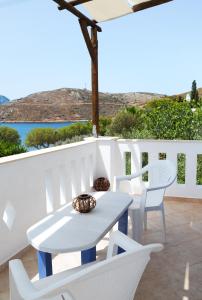 a white table and chairs on a balcony with the ocean at Petroula Apartments II in Emborios