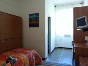 a bedroom with a bed and a tv and a window at Hotel Mignon Posta in Rapallo