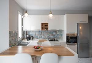 eine Küche mit einem Holztisch und weißen Schränken in der Unterkunft Vanilla Luxurious Apartment in Kavala