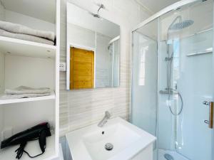 a white bathroom with a sink and a shower at Arina & Julien Dieppe in Dieppe