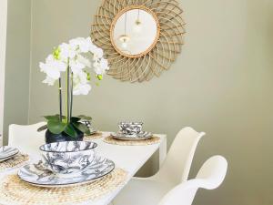 a white table with a mirror and white flowers on it at Arina & Julien Dieppe in Dieppe