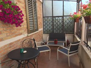 a patio with a table and chairs and flowers at Itaka in LʼAquila