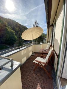 einen Balkon mit 2 Stühlen und einem Sonnenschirm in der Unterkunft Ferienwohnung Gipfelstürmer in Bad Harzburg
