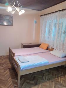 1 dormitorio con 1 cama y una ventana con sábanas rosas en HOSTEL BATA II Trokrevetne sobe, en Kanjiža