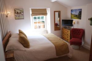 1 dormitorio con 1 cama y 1 silla roja en West End Guest House en Richmond