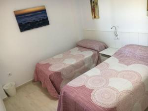 Habitación con 2 camas y una foto en la pared. en Apartamento Beach en Los Caños de Meca