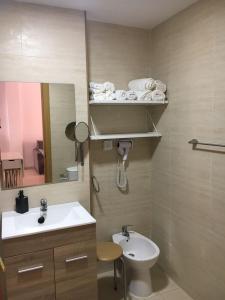 a bathroom with a sink and a toilet and a mirror at Apartamento Beach in Los Caños de Meca