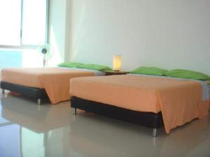 2 Betten nebeneinander in einem Zimmer in der Unterkunft Costazul Suites 705 in Santa Marta