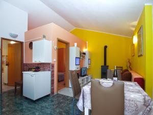 a kitchen and dining room with yellow walls and a table at House Vodnjan 2106 in Vodnjan +11 photos